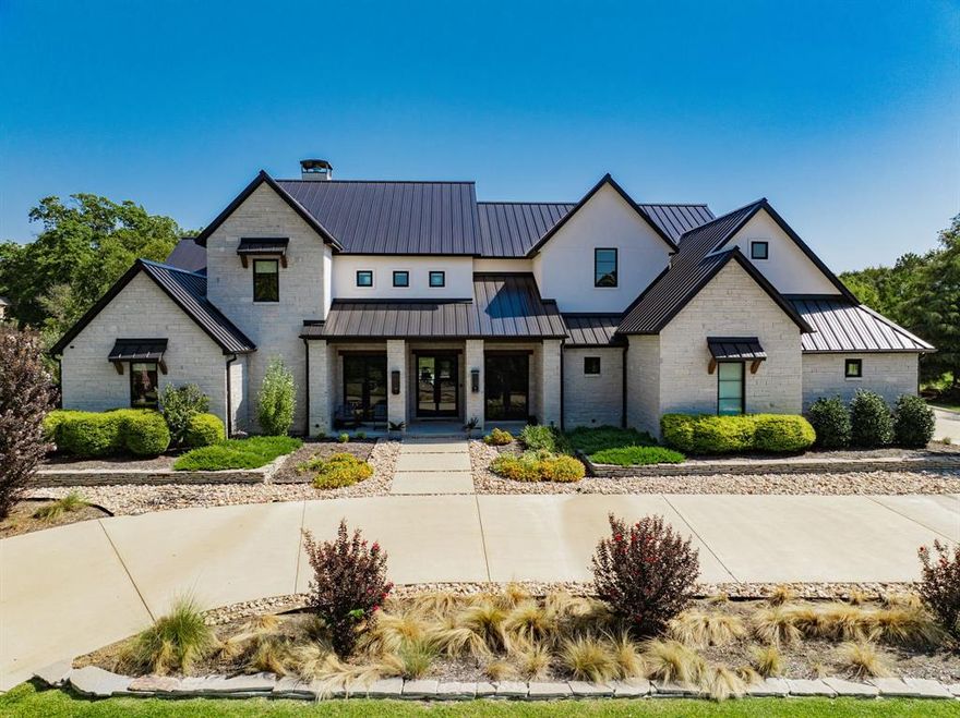 Welcome to your dream retreat—an exceptional modern luxury home built in 2020, perfectly situated on a spacious 1.467-acre lot directly across from the serene waters of Lake Ray Hubbard! This stunning 5 bedroom, 5 bathroom estate offers 5,002 sqft of living space, 7,157 sqft total under roof and is designed for both upscale living and effortless entertaining. Inside, clean lines and high-end finishes define the open-concept layout. The chef’s kitchen is a true showstopper, complete with a gas range, built-in refrigerator, double ovens, a drawer fridge, floor to ceiling wine rack, and ample custom cabinetry. Adjacent is a spacious living area flooded with natural light. You'll find a dedicated office featuring custom built-ins—perfect for working from home in style. The primary suite is a private oasis, boasting his-and-hers everything—double toilets, vanities, and sinks—along with generous walk-in closets. Each additional bedroom is spacious and thoughtfully laid out, offering comfort and privacy with its own ensuite bathroom. 4 bedrooms are located on the first floor along with the game room and office! Upstairs features another living area, the 5th bedroom and a bonus room with closet; perfect for a in-law suite set up to have own bedroom and living room. Step outside to your covered patio with outdoor kitchen overlooking a sparkling pool, putting green and expansive fenced backyard—ideal for relaxing, entertaining, or simply soaking in the peaceful atmosphere. A spacious 4-car garage and ample parking with a double wide driveway to provide plenty of room for vehicles and guest. For added convenience, this property is equipped with smart home features that control garages & lights with the touch of a button from your phone, as well as having a surround sound system installed inside, outside and around the pool! Luxury, comfort, and location all come together in this one-of-a-kind property. Don’t miss the opportunity to own this extraordinary home with lake views.