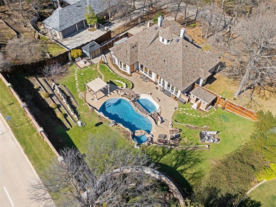 REDUCED PRICE! Step into timeless elegance with this magnificent Mediterranean estate, perfectly positioned on one of the most coveted lots inside the prestigious gated community of River Bend. Set on an impressive home site, this property delivers a private backyard retreat that truly feels like your own resort. Outside, mature trees frame terraced grounds designed for both entertaining and quiet relaxation. The sparkling pool and spa, pergola lounge area, and multiple gathering spaces are surrounded by lush landscaping, creating an oasis you’ll never want to leave. Inside, breathtaking double French glass doors open to a dramatic entry highlighted by a wood-beamed ceiling, gas fireplace, art niches, graceful archways, and updated lighting throughout. The open-concept layout seamlessly connects the dining room, kitchen, and breakfast nook, ideal for everyday living and hosting alike. The dining room impresses with hand-scraped wood floors and stunning fresco ceiling details. The chef’s kitchen is built to perform, featuring a gas range, Sub Zero refrigerator-freezer, and abundant cabinet and counter space for effortless meal prep and entertaining. Privately situated in its own wing, the spacious primary suite offers a serene sitting area and a wall of windows that flood the room with natural light. The luxurious en suite bath includes an oversized walk-in shower, garden tub, dual vanities, and a custom walk in closet. Two secondary guest bedrooms with a connecting bath ensures visitors enjoy comfort and privacy. A quiet home office or studio just off the garage provides the perfect work from home setup. Additional exterior features include a greenhouse for the gardening enthusiast, a She shed, and extra storage space. Energy efficient upgrades, including custom blinds throughout, enhanced attic insulation, new energy efficient windows, and major system updates within the past five years, including the roof, gutters, pool, pond, and irrigation system.