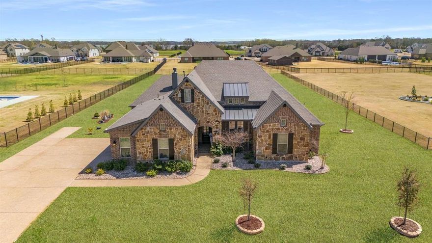 Set on over an acre just minutes from Lake Lavon, this exceptional single-story residence offers the space, privacy, and flexibility today’s buyers are seeking. Paired with a level of quality that rivals new construction. With plenty of room to design your dream outdoor retreat, the expansive homesite presents a rare opportunity to add a custom pool or outdoor living all while enjoying wide-open surroundings. The 1-story floor plan delivers both functionality and flow, with an open-concept living space featuring vaulted ceilings, a striking center beam, beautiful wood flooring, and a wood-burning gas fireplace that brings character to the home. The elevated and functional gourmet kitchen showcases an oversized island, quartz countertops, glass-front cabinetry, farmhouse sink, and premium stainless appliances including a 6-burner gas cooktop and double convection ovens. The private study with French doors and built-ins offers a refined work-from-home space, while the game room provides flexibility for media, hobbies, or everyday living. The primary suite is a true retreat with a tray ceiling and a spa-inspired bath complete with dual vanities, freestanding soaking tub, frameless glass shower with bench seating, and a custom walk-in closet with direct access to the utility room. One secondary bedroom features a private ensuite, while two others share a Jack-and-Jill bath with dual sinks and a built-in desk area. The covered patio with a gas-plumbed grill is ideal for entertaining, overlooking a backyard with endless potential. A wide driveway and 3-car garage offer both convenience and storage, while energy-efficient systems and smart home features enhance everyday living. For those seeking land, lifestyle, and a home that lives like new, this is a rare opportunity to have it all. Lovejoy Scholars program allows children who do not live within Lovejoy ISD’s boundaries an opportunity to apply for limited application-based enrollment to attend schools in LISD.