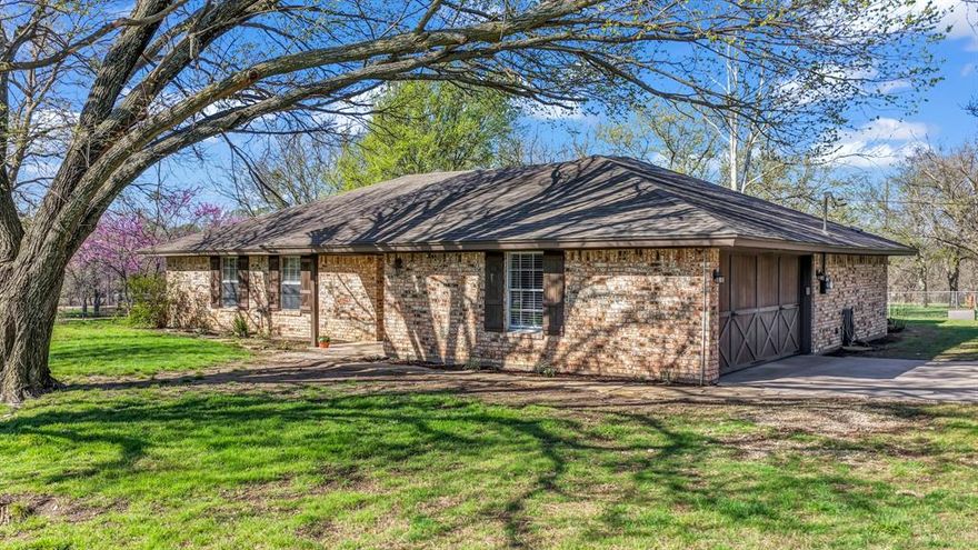Location, Location, Location! This charming three-bedroom, two-bathroom home is nestled an expansive 3.52-acre corner plot of unrestricted land in an unincorporated area of Tarrant County. The spacious living room features a stunning wood-burning fireplace and elegant wood flooring that seamlessly transitions into the dining area. The bedrooms are adorned with ceramic tiles, while the dining room boasts bay windows. A separate shower and dual vanity is located in the primary bath, and the entire home has been freshly painted. The property is fully fenced with cross fencing and an electric entry gate. The two-car garage floor is epoxy and includes a bonus room. The outdoor space offers a storm shelter, large covered patio, storage, workshop, chicken coop, and mature trees throughout the property. This property has immense potential due to its location in an unincorporated area with no restrictions. The frontage to FM 718 offers excellent opportunities for commercial development. This idyllic country home offers the perfect blend of tranquility and convenience, conveniently located near shopping centers, schools, and major highways, including Highway 287, 114, 35, and Business 287. Mineral rights will convey.
