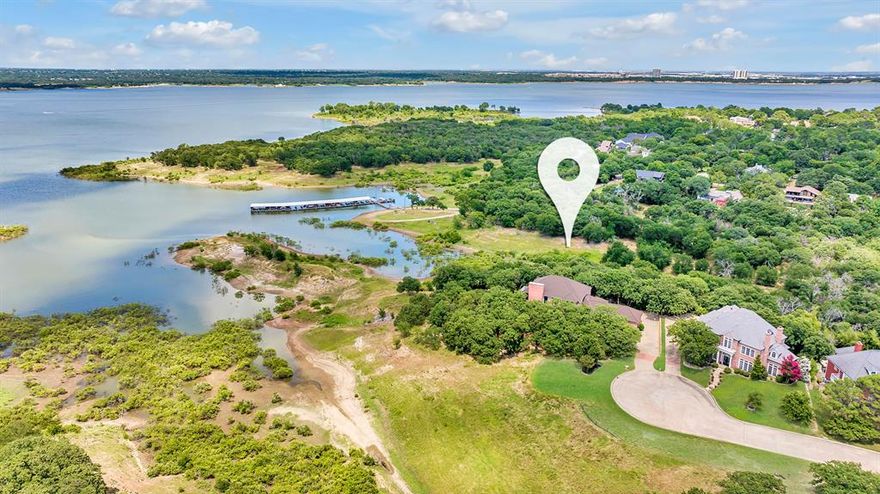 Extraordinary opportunity to own a stunning property at the end of a serene cul-de-sac, spanning 1.16 acres with breathtaking views of Grapevine Lake and direct access to Corp property. This remarkable estate that has never before graced the market, offers a unique blend of privacy, nature, and natural beauty. The street, lovingly named Labrador Bay by its developer in homage to her affection for Labrador dogs, sets the tone for a home that harmonizes with nature. Designed with the animal enthusiast in mind, this stately residence includes a dedicated 3-dog kennel and provides ample opportunities for wildlife and bird watching, as well as enjoying the serene sights of fish jumping in the lake. As you step inside, you're greeted by a beautifully open floorplan adorned with luxurious travertine floors. French doors lead to a covered patio, expanding the living space and offering panoramic, tree-lined views of the lake. The main floor is perfectly suited for entertaining, reflecting the owner's passion for hosting, and includes a convenient guest suite. The centrally located kitchen is complete with Thermador appliances, granite counters, and stately stained cabinets. Upstairs, the grand primary bedroom features a cozy sitting area and offers unparalleled views of the lake, ensuring a peaceful retreat. An additional bedroom completes the upper level, providing ample space for family or guests. A 3-car garage is discreetly located at the back of the home, preserving the property's elegant façade. This is a rare gem where comfort, style, and nature seamlessly blend—ready for you to create updates and cherished memories.