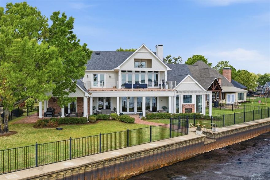 Welcome to your dream lakeside retreat! This completely updated and expanded, French Quarter-inspired home combines luxurious living with breathtaking water views in sought-after Pinnacle Club. Step inside to discover spacious, light-filled interiors designed for both relaxation and entertaining. The sophisticated living room features a coffered ceiling and custom-built shelving, creating an inviting atmosphere anchored by a striking brick fireplace. At the heart of this home is the gourmet chef’s kitchen with its 17-foot island, and equipped with a SubZero fridge, Thermador 6 burner + griddle range, oversized sink with removable workstation, two Bosch dishwashers, Bosch double ovens, dual Sharp drawer microwaves, climate controlled wine fridge and beverage fridge - perfect for culinary enthusiasts and gatherings alike. The open-concept dining area seamlessly connects to both the living space and the brick-paved lakeside veranda, where multiple seating areas, ceiling fans, heaters, and a grill station make year-round outdoor enjoyment a reality. Retreat to the lakeside primary bedroom, complete with picturesque views, a cozy sitting area with a fireplace, and luxurious ensuite boasting heated floors and dual vanities. Families and guests alike will appreciate the upstairs game room with fireplace and wet bar, and four charming bedroom suites that offer ample space for relaxation and personalization. The outdoors beckon with a private two-story boathouse, deep-water access, and a swing dock ideal for soaking in panoramic views. The massive second-floor deck further enhances your entertaining options while the beautifully landscaped grounds provide refined curb appeal. Upgrades include a whole-home water filtration and softener system, whole-home generator and tankless water heaters. Don’t miss your chance to own this exquisite lakeside property, where luxury living meets nature's tranquility.