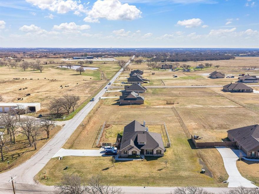 Welcome to this beautiful 3 bedroom, 2.5 bathroom brick and stone home located in the desirable Honeysuckle Ranch community in Paradise, Texas. Designed with both comfort and functionality in mind, the home features an inviting open-concept layout where the kitchen, dining, and living areas flow seamlessly together—perfect for everyday living and entertaining. The kitchen is the heart of the home, complete with a large center island, granite countertops, stainless steel appliances, and a double oven that makes cooking for family gatherings a breeze. The living room is filled with natural light and features a cozy wood-burning fireplace with gas starter, creating the perfect spot to relax. A convenient half bath is located just off the living area for guests. The primary suite offers a private retreat with an en-suite bathroom and a spacious walk-in closet. Two additional bedrooms share a well-appointed bathroom, providing plenty of space for family or guests. Step outside and you’ll find an incredible backyard built for entertaining. The extended covered patio features a full outdoor entertainment area complete with a built-in grill, refrigerator, separate bar seating area, and a beautiful wood-burning outdoor fireplace—perfect for hosting friends or enjoying peaceful Texas evenings. The backyard is enclosed with pipe fencing for added security, while still offering plenty of space to add a shop, pool, or create the backyard of your dreams. Located in a fantastic area with highly sought-after Paradise ISD, this property offers the perfect combination of peaceful country living with modern amenities.
Don’t miss the opportunity to make this one yours.