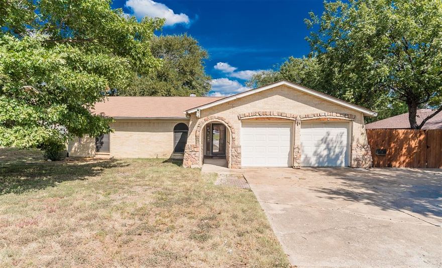 Tucked in an established North Richland Hills neighborhood, this single-story home welcomes you with a charming stone-arched entry and a two-car garage. Inside, a vaulted living room with exposed beam and a striking floor-to-ceiling stone fireplace sets the tone for cozy nights in. The light, eat-in kitchen opens to a bright dining area with wall-to-wall windows and a large sliding door to the covered patio. Perfect for morning coffee or weekend grilling. Easy-care flooring runs through the main spaces, bedrooms include generous closet storage, and the fenced backyard offers room to play, garden, or add a shed. A fantastic canvas to make your own, with convenient access to local shopping, dining, and commuter routes.
