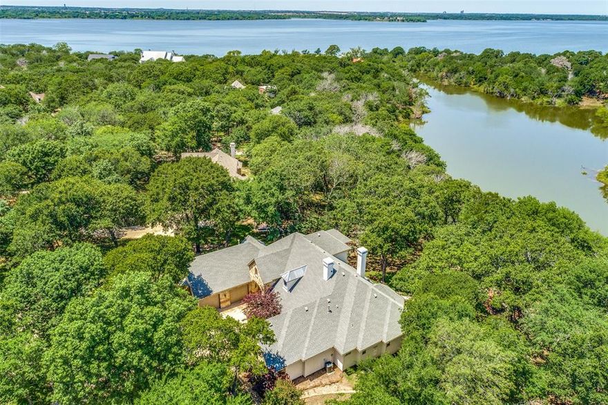 This property is a waterfront paradise! Award-winning Custom Builders personal home nestled on a unique 1.1 acre Lakefront lot in exclusive Eagles Landing. Enjoy the breathtaking views of Lake Lewisville surrounded by a canopy of trees. Play with your water toys on the lake, relax by the firepit and watch the gorgeous Texas sunset. The tree-lined outdoor acreage offers unlimited possibilities to include a pool and additional patio areas to the waterfront. The enclosed outdoor living area with an impressive stone fireplace opens to an expansive terrace. Open the sliders and bring nature indoors. Windows across the back of the home allow views of the lake from the kitchen, living room, & bedrooms. Gameroom upstairs doubles as a 4th bedroom ensuite. Enjoy morning coffee on the covered terrace overlooking the trees and Lake Lewisville. Don't miss the additional attached guest stuido designed for multi-generational living, a remote office, studio, etc... Complete with a kitchenette, living-bedroom suite with a full bath and private entrance! The 3-car garage will easily hold all of your vehicles, toys, watercraft and equipment. The workshop-garage has an extra powder bath connected. 

This unique lakefront property extends into the water without Corp of Engineer access along the back of the lot as so many Lake Lewisville properties. The builder-owner added a partial fence to keep the family Labrador from jumping in the lake constantly. The fence can be removed or extended. An infinity edge pool overlooking the lake would be fabulous!!

The custom builder could possibly make construction modifications if the buyer requests!

This beautiful custom home is tucked into a quiet enclave yet less than 10 minutes to shopping and dining. Located 5 minutes of Willow Bend Polo Club, Dallas Corinthian Yacht Club, miles of nature trails and Oak point boat ramp. You do not want to miss out on this rare opportunity for luxury lakefront living this summer!