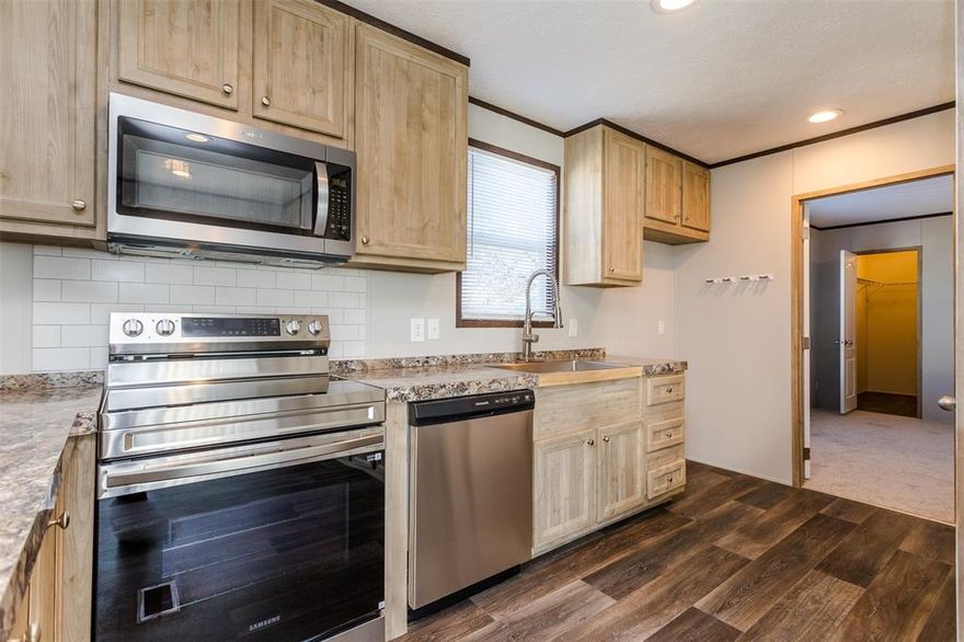 Stunning and affordable home with stainless steel appliances! Completely move in ready and in excellent condition. Current monthly lot rent of 623 a month. Keep it here and pay lot rent or move it to your own land.  Parking spaces are right up front. This sale does not include land just the home, land is leased monthly. Quiet community with pool and central location right off 35 with quick access to anywhere. REO property perfect for investors or first time buyers but with minal to no work required.