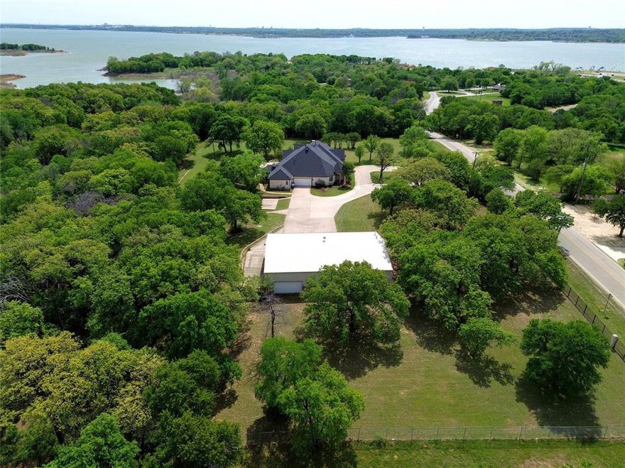 Set on approximately four private, tree-lined acres in the highly desirable southern portion of Flower Mound, 1000 Simmons Road presents a rare opportunity to own a one-of-a-kind luxury estate that blends timeless Texas character with modern refinement.

Constructed in 1997 and extensively renovated in 2022, this custom single-story residence has been thoughtfully updated to meet today’s expectations of elevated living while preserving the scale and warmth of a classic North Texas estate. Spanning approximately 4,430 sqft, the home offers four spacious bedrooms, four full bathrooms, and a well-appointed powder bath, all within a layout designed for both everyday living and entertaining.

The interior features expansive living areas filled with natural light, highlighted by panoramic, ceiling-height windows in the family room that capture views of the surrounding landscape and pool. The kitchen is designed for casual function with a view. Oversized bedrooms and a large game room with access to the outdoor setting that offers a private retreat, a pool with a waterfall feature and areas for relaxation and entertaining.

The surrounding acreage, mature trees, and open views contribute to a quiet, secluded atmosphere rarely found in this location.  The natural setting is enhanced by frequent sightings of wildlife, including deer, rabbits, and squirrels, creating a tranquil, almost resort-like environment.

A defining component of the estate is the detached approximately 3,500-sqft garage, and workshop structure, along with an updated 1,000-square-foot garage apartment. This versatile space significantly enhances the property’s utility, accommodating car collections, RV storage, recreational use, indoor sport court potential, or a home-based business setup. With its combination of privacy, usable acreage, modern updates, and improvements, 1000 Simmons Road stands out as well-suited for buyers seeking space, functionality, and a refined yet practical lifestyle.