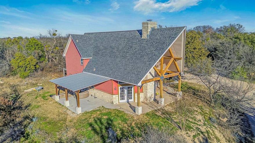 Perched atop a wooded hillside, this refined Texas country estate offers privacy, space, and timeless character. The property features a newly built detached 1-bedroom, 1-bath guest suite with a full kitchen and living area, approx. 800 sq ft, ideal for multigenerational living, guests, or income potential.

The main residence spans over 2,200 sq ft, showcasing soaring vaulted ceilings, abundant natural light, and a dramatic 30 foot Austin stone fireplace anchoring the living space. A well appointed kitchen includes dual walk-in pantries for exceptional storage. The primary suite opens to a private balcony overlooking the treetops and is complemented by a recently updated ensuite bath.

Flexible living continues with two spacious lofts and an additional upstairs room with two closets. Three new HVAC systems ensure comfort and efficiency.

Set on 2.25 private acres with mature pecan trees, native landscaping, and visiting wildlife, the outdoor spaces are designed for both relaxation and entertaining, featuring covered patios and a newer pergola. A 16×20 powered workshop with carport and a 2023-built 30×30 concrete floor barn provide exceptional space for RVs, equipment, or recreational vehicles. Conveniently located with quick access to Downtown Fort Worth and Weatherford, and major shopping just minutes away.