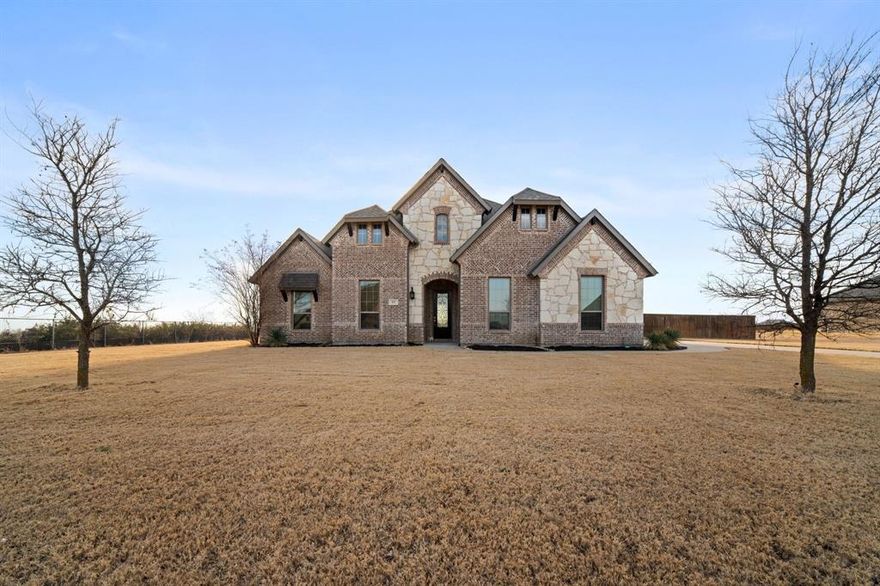 Move-in ready and set on over an acre outside city limits, this home offers peaceful country living with wide open views.  Inside the floorplan is a dream with 4 bedrooms, 3 full baths and 2 living areas. The downstairs family room with cozy fireplace flows into the bright and cheery eat-in kitchen with Quartz countertops, Texas size island and tons of counterspace, creating an inviting space for everyday living. The large primary retreat features a garden tub, separate shower, his and her vanities, and walk in closet. Desirable split bedroom layout with 3 other bedrooms downstairs. Upstairs is a spacious flexible game room upstairs with its own full bath, perfect for guests, hobbies, or a second living area. Outside, you’ll find a 2-car garage plus a separate 1-car garage that opens to the backyard; ideal for storage, projects, or outdoor equipment. The property backs to a quiet pasture, and the neighboring utility lot provides extra space and privacy. Level 4 roof, gutters and garage doors less than a year old! This beautiful home offers flexibility, and a serene setting just minutes from town. Don't miss!
