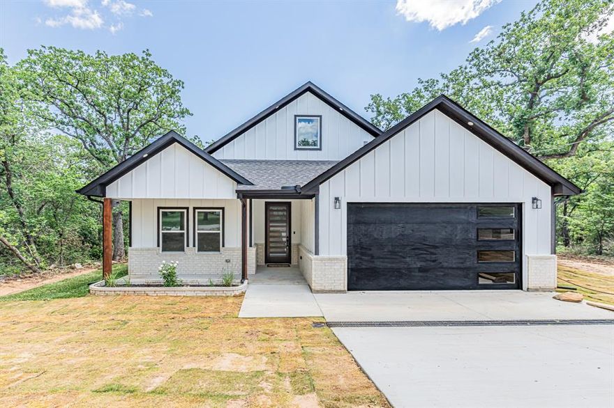 Step into modern elegance with this brand new 4bed, 2.5bath home featuring a sleek open concept design and stylish finishes throughout. From the moment you walk in, you’ll love the bright white interior, wood flooring throughout the main living areas, natural light flows throughout home, and the decorative electric fireplace that creates the perfect focal point in the spacious living room. The stunning kitchen offers crisp white cabinetry, kitchen island, stone countertops, a walk in pantry, convection oven, microwave, and plenty of prep and storage space, all overlooking the dining and living areas for easy entertaining. The private primary suite features plenty of room to unwind along with a luxurious ensuite bath complete with a huge walk in shower, dual sinks, separate vanity space, and a spacious walk in closet with a custom closet system. Two secondary bedrooms offer generous closet space and share a beautifully finished full bath with tiled tub shower combo and stone countertops. A fourth bedroom located at the front of the home would also make the perfect office or flex space and is conveniently located near the half bath. Enjoy the outdoors from the covered back patio overlooking a backyard filled with mature trees, fresh sod, and a newly built retaining wall with steps. With LVP flooring in the bedrooms, tile in the bathrooms, modern finishes throughout, and thoughtful upgrades in every room, this home is move in ready and waiting for its forever owners.
