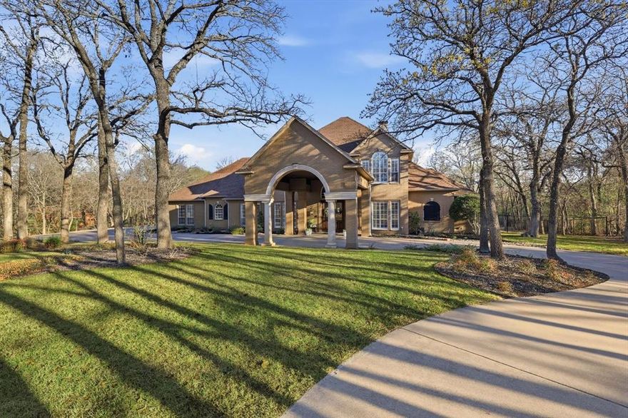 Situated on 1.9 wooded acres in prestigious Shadow Wood Estates, this exceptional Argyle estate offers luxury living within highly sought-after Argyle ISD, feeding to Hilltop Elementary. Spanning 4,336 square feet, the home features 4 bedrooms, 5 bathrooms, a media room, and a spacious playroom, designed for both elegant entertaining and comfortable everyday living.

A stunning curved staircase creates a grand first impression, leading into beautifully appointed interiors with hand-scraped hardwood floors, fresh paint throughout, and stylish designer lighting. The inviting family room showcases a fireplace and a dramatic wall of windows overlooking the resort-style backyard, filling the home with natural light and scenic views. A private office with fireplace provides an ideal work-from-home retreat.

The well-appointed kitchen features granite countertops, gas cooktop, double ovens, a butler’s pantry, and a charming breakfast nook, seamlessly connecting to the main living spaces. The spacious primary suite offers a luxurious retreat with two closets, including an oversized closet extending nearly the full width of the bedroom.

Step outside to a breathtaking outdoor oasis featuring a pool with infinity edge, spa with waterfall feature, new pool deck, fire pit, and extensive new landscaping surrounded by mature trees for privacy. A screened-in patio and upstairs balcony overlook the expansive backyard and pool, creating multiple spaces to relax and entertain.

Additional highlights include a Sonos integrated sound system, new AC unit (2024), and a rare 4-car garage, completing this remarkable luxury property in one of Argyle’s most desirable communities.