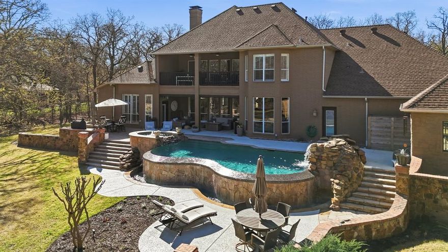 Situated on 1.9 wooded acres in prestigious Shadow Wood Estates, this exceptional Argyle estate offers luxury living within highly sought-after Argyle ISD, feeding to Hilltop Elementary. Spanning 4,336 square feet, the home features 4 bedrooms, 5 bathrooms, a media room, and a spacious playroom, designed for both elegant entertaining and comfortable everyday living.

A stunning curved staircase creates a grand first impression, leading into beautifully appointed interiors with hand-scraped hardwood floors, fresh paint throughout, and stylish designer lighting. The inviting family room showcases a fireplace and a dramatic wall of windows overlooking the resort-style backyard, filling the home with natural light and scenic views. A private office with fireplace provides an ideal work-from-home retreat.

The well-appointed kitchen features granite countertops, gas cooktop, double ovens, a butler’s pantry, and a charming breakfast nook, seamlessly connecting to the main living spaces. The spacious primary suite offers a luxurious retreat with two closets, including an oversized closet extending nearly the full width of the bedroom.

Step outside to a breathtaking outdoor oasis featuring a pool with infinity edge, spa with waterfall feature, new pool deck, fire pit, and extensive new landscaping surrounded by mature trees for privacy. A screened-in patio and upstairs balcony overlook the expansive backyard and pool, creating multiple spaces to relax and entertain.

Additional highlights include a Sonos integrated sound system, new AC unit (2024), and a rare 4-car garage, completing this remarkable luxury property in one of Argyle’s most desirable communities.