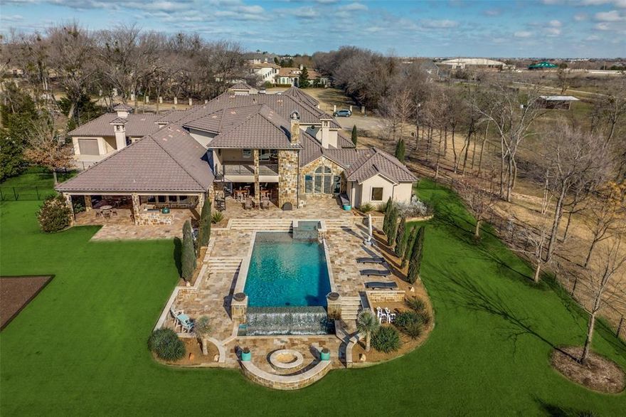 WELCOME TO YOUR STUNNING PRIVATE EXECUTIVE OASIS WITH PARK-LIKE SETTING IN HIGHLY DESIRABLE PROSPER SCHOOLS NEIGHBORHOOD. ON THE FIRST LEVEL IS A HOME OFFICE, EXERCISE ROOM WITH PRIVATE PATIO, TWO DINING AREAS, SPACIOUS FAMILY ROOM, SAFE ROOM,LAUNDRY ROOM WITH PET SHOWER,OPEN KITCHEN WITH CHEF’S STYLE WOLFE COOKING CENTER AND WINE ROOM. PRIMARY SUITE WITH TWO-SIDED FIREPLACE SEPARATED WITH SUN-DRENCHED SITTING ROOM.  GUEST QUARTERS WITH FULL BATH, AMENITY CENTER AND PRIVATE ENTRANCE.  ELEVATOR TO SECOND FLOOR FEATURES THREE BEDROOMS, LAUNDRY ROOM, MEDIA ROOM, GAME ROOM AND WALK OUT BALCONY WITH FIREPLACE. PRIMARY BATH HAS UNIQUE SANDSTONE TUB, SEPARATE SHOWER AND WIC. OUTDOORS IS A LUXURIOUS RESORT STYLE INFINITY POOL, FIRE PIT, WATERFALL, COMPLETE COOKING CENTER, POND, PLAYGROUND AND 3200SF PUTTING GREEN. TWO DOUBLE CAR GARAGES, SINGLE CAR GARAGE, LARGE WORKSHOP, PLUS EV CHARGING STATION. MINUTES FROM HWY 121, DALLAS NORTH TOLLWAY, SHOPPING, DINING AND AIRPORTS, ALL EASILY ACCESSIBLE.