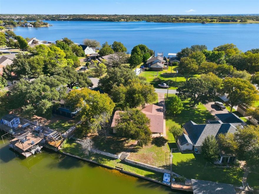 Charming waterfront property with a beautiful view located in the quiet Indian Harbor development of Lake Granbury. This home sits at the end of a quiet cul de sac and has been lovingly maintained. There are so many unique touches to love in this home, like the  original mid century modern front door to the beautiful petrified wood fireplace.  You will also find new flooring throughout the bedrooms and living area.  Both bathrooms have been remodeled within the year. The bedrooms are all nicely sized, and the primary suite offers water views. The living, kitchen and dining areas all flow openly and provide water views from the windows and back door. 
Whether for coffee and sunrises or wine and sunsets, the covered back porch is sure to become one of your favorite places.  
No matter if you love lake living or are just searching for a a charming home in a quiet and friendly neighborhood, this is a gem you don't want to miss.
No sellers disclosure or survey are available.