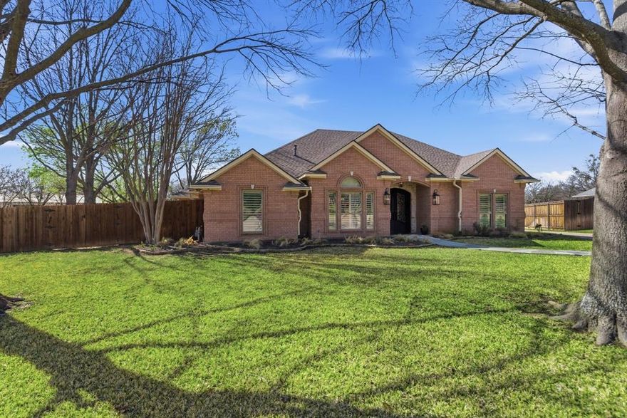 Don’t miss the rare opportunity to own this one-of-a-kind, stunningly updated traditional gem. Nestled in a desirable neighborhood among lush fruit and nut trees, this brick home offers exceptional curb appeal and the privacy of backing up to a peaceful mini-ranch. Step through the double iron doors into a breathtaking entryway featuring grass-cloth walls, showstopping wood-beamed ceilings, and a luxury chandelier. Throughout the home, you’ll find durable wood-like tile flooring, custom lighting, and brand-new windows fitted with 3 inch blinds. The heart of the home is a chef’s dream kitchen, boasting professional-grade 6-burner gas range top with a griddle, double ovens and a sleek concealed refrigerator. Expansive counter space and an open view of the living area which is anchored by a custom built-in entertainment center with adjustable glass shelving and dimmable lighting—perfect for cozy movie nights by the fireplace. This thoughtful one-story floor plan features a unique 3-way split for maximum privacy. 4 Spacious Bedrooms; each featuring walk-in closets, ceiling fans, and recessed lighting. The primary retreat is a spa-like sanctuary with a massive walk-in shower, dual shower heads, a built-in bench, and an adjustable steam-venting window. All bathrooms have been smartly updated with custom cabinetry, exquisite mirrors, and beautiful marble and tile finishes. The game room seamlessly transitions from indoor to outdoor fun through sliding glass doors that lead to an extended patio with a mounted TV. Behind a stylish sliding barn door lies a mudroom with a separate exterior entrance leading to a bonus room or office—ideal for a home-based business. The Garage; an oversized 3-car garage designed for flexibility, allowing tandem parking up to 6 compact cars. Escape to your private backyard paradise. Relax under the stars on the extended patio or take a dip in the sparkling saltwater pool. This residence checks all the boxes.