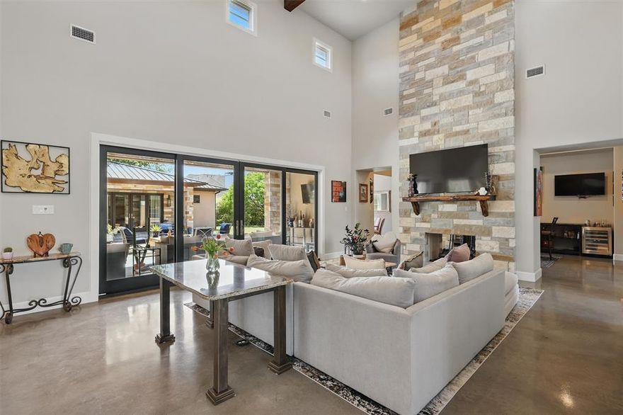 Located on a premier street in sought-after Riverhills, this exceptional Texas vernacular-style home blends rustic elegance with modern functionality. Set on a beautifully landscaped .36-acre lot, the residence showcases a dynamic mix of stone, wood, and concrete—hallmarks of the region’s architectural charm. The open-concept first floor is anchored by a stunning two-story double-sided stone fireplace, creating a warm and inviting atmosphere between the family room and adjoining space that is currently used as a bar area with separate climate-controlled wine room. The gourmet kitchen opens seamlessly into the family room and is complemented by a back kitchen. The spacious primary suite on the main level features a luxurious bathroom and a generously sized walk-in closet. An additional guest suite with its own private bath is also conveniently located on the first floor. Upstairs, you'll find two more bedrooms, each with ensuite bathrooms and a versatile loft area that overlooks the main living space below. In addition to the main residence, the property includes a separate casita with a private bedroom and full bath—ideal for guests or multigenerational living. Above the three-car garage is a large bonus room with a half bath, perfect for a home office, studio or additional game room. The backyard is built for Texas living, with an outdoor kitchen, covered living space, and open fire pit—with plenty of room remaining to add a custom pool. Located in the heart of Riverhills, one of Fort Worth’s most desirable neighborhoods, this home offers cameras at each entrance, thoughtfully preserved green spaces and a lively community with regular neighborhood activities. All just minutes from Clearfork, the private school corridor and the best of central Fort Worth.