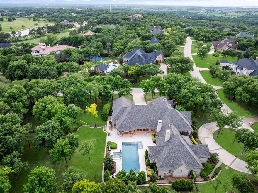This sophisticated single-story home on a premier 1.6-acre corner lot within the 24-7 guard-gated Estates of Tour 18 was custom-built just ten years ago and elevated by the current owners - leaving nothing for the next owner to desire. Ideally located in highly acclaimed Argyle ISD and minutes from Liberty Christian School, it offers elite security and a vibrant golf course lifestyle.
Meticulously modernized, the home is anchored by a Control4 smart system providing seamless control of lighting, audio, and an 8-camera LumaLink security network. Significant upgrades include: wide-plank White Oak flooring, fresh interior paint, designer lighting throughout, saltwater pool conversion with new heater, a Generac generator, 2 tankless water heaters, spray foam insulation in the attic, whole-house surge protectors, EV chargers, a whole-house water filtration and softener system.
At the heart of the residence, the main living area features soaring cathedral ceilings with architectural timber trusses and opens to a chef’s kitchen designed for entertaining with double islands, a showpiece walk-in pantry, and an adjacent climate-controlled wine storage room. The thoughtful layout includes four en suite bedrooms, a private media room with upgraded theater lighting and carpet, and a spacious game room. The owner’s wing features the primary suite with two spacious walk-in closets, a spa-style bath with heated floors, a dedicated second laundry, and a private study.
Designed for multi-generational living, the guest bedroom suite is positioned on its own private wing, offering enhanced separation and privacy, and convenient access to one of two attached oversized two-car garages. Above the garage, a dedicated exercise room with custom mirrors provides a private wellness retreat.
Beyond the gates, residents enjoy exclusive access to the world-class Tour 18 Golf Course and Country Club, offering a lifestyle that blends championship golf with the serenity of a private sanctuary.