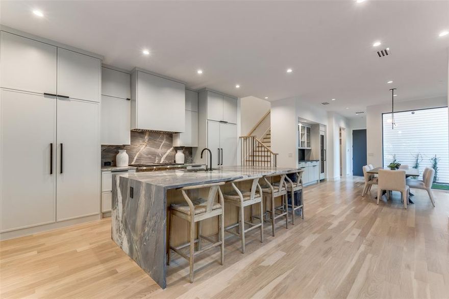 Perfectly situated across from the iconic Highland Park Fountain on a quiet, low-traffic street, this stunning three-level home blends sophisticated design with effortless urban living. This residence is thoughtfully designed to deliver both style and functionality. Step inside to a light-filled interior where soaring ceilings and expansive windows highlight the sleek, contemporary finishes. The gourmet kitchen is a chef’s dream, featuring premium appliances, custom cabinetry, and an oversized marble island ideal for entertaining or casual dining. The open-concept living and dining areas create a seamless flow, making this home perfect for gatherings both large and small. This residence is fully tech-enabled, featuring in-ceiling speakers, Wi-Fi extenders, HD big-screen TVs, a private circuit security camera system, and electronic shades throughout , all designed for modern convenience and peace of mind. The second-floor primary suite serves as a serene retreat, boasting a luxurious spa-like bathroom with high-end fixtures, a soaking tub, and generous closet space. Two additional bedrooms, each with en suite bathrooms, provide comfort and privacy for family or guests. Outdoor living is a true highlight, with a private ground-level patio and a partially covered rooftop deck with an electronically controlled roof that opens and closes, perfect for quiet nights under the stars or entertaining with panoramic views. With unmatched walkability to the Shops at Highland Park and nearby dining and entertainment, this home offers the best of Dallas living in one of the city’s most desirable neighborhoods. This property is a rare opportunity to enjoy upscale finishes, cutting-edge smart home technology, a prime location, and exceptional design.