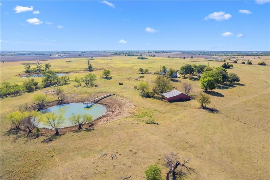 Home among the rolling pastures of West, Texas, sits a nearly 30 acre property with multiple tanks, the classic Red Barn, workshop and partially finished guest house (the ultimate project for a woodworker). This traditional home is positioned far off the road leaving front pasture open for grazing livestock and a true country-living appeal. The home is the perfect live-in-while-you-update project and features a large country kitchen and massive living room. The detached metal building includes the guest house, an office, and storage area. Don't miss the opportunity to raise any species of younglings on these expansive grounds - the human kind would especially love fishing from the dock over the large tank. (Tanks are man-made ponds BTW) C'mon out and enjoy the fresh air, and famous kolaches, of West, Texas!