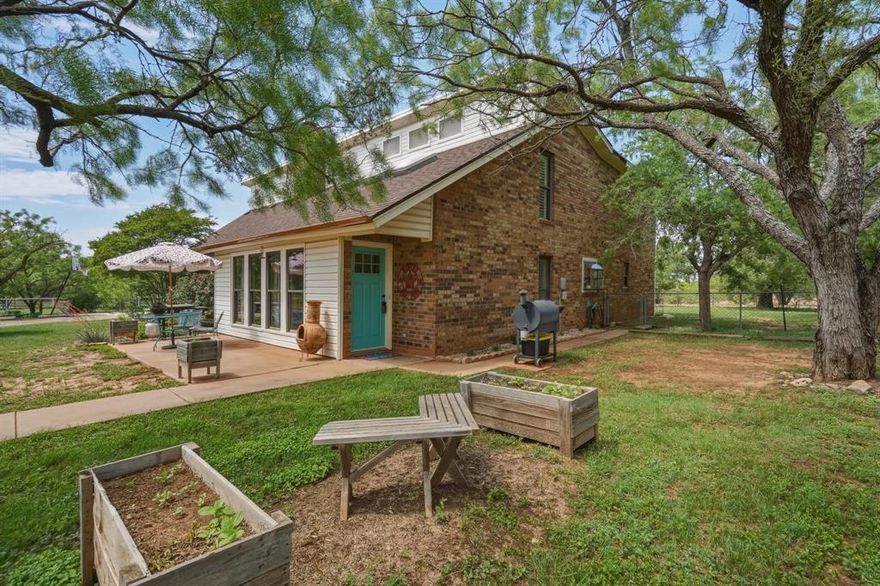 Owner-Agent. House, Large Tank, Dock, Zipline, Barn, Shed, Acreage, Privacy Gate, Fenced for Livestock, Room to Grow, AND MORE! Discover true Texas country living just outside Abilene city limits on 3.95 peaceful acres of acreage across two parcels. This charming and sprawling 1982 two-story ranch home, full of character and whimsy offers 4 generously sized bedrooms, 2.5 baths, and 3,193 sq ft of comfortable living space featuring two large living areas—one downstairs and a spacious loft upstairs—granite countertops, a gas stove, large walk-in pantry, plantation shutters, wood-burning fireplace, a primary suite with office, and a large balcony and so much more! This flexible property is perfect as a country oasis while the acreage and additional parcel offers excellent potential to add a second home, guest house, or a short term or long term rental unit for extra earning potential. Outside, enjoy a stocked tank with koi and goldfish complete with dock and zipline, cross-fenced pastures ready for horses or livestock, a cattle chute, large red barn, and copper-roofed shed—all framed by native mesquite trees and open skies. The large front and back porches plus balcony offer perfect relaxing spaces to sip morning coffee or tea, listen to music, read a book, or simply unwind while taking in breathtaking sunrises, fiery sunsets, distant mountain views, and endless Texas stars. With a new roof and gutters, recent septic service, and most 2025 inspection items addressed, this gated hobby farm delivers peace of mind and amazing potential for growth. Come and see the perfect blend of ranch-style comfort and wide-open freedom in West Texas!