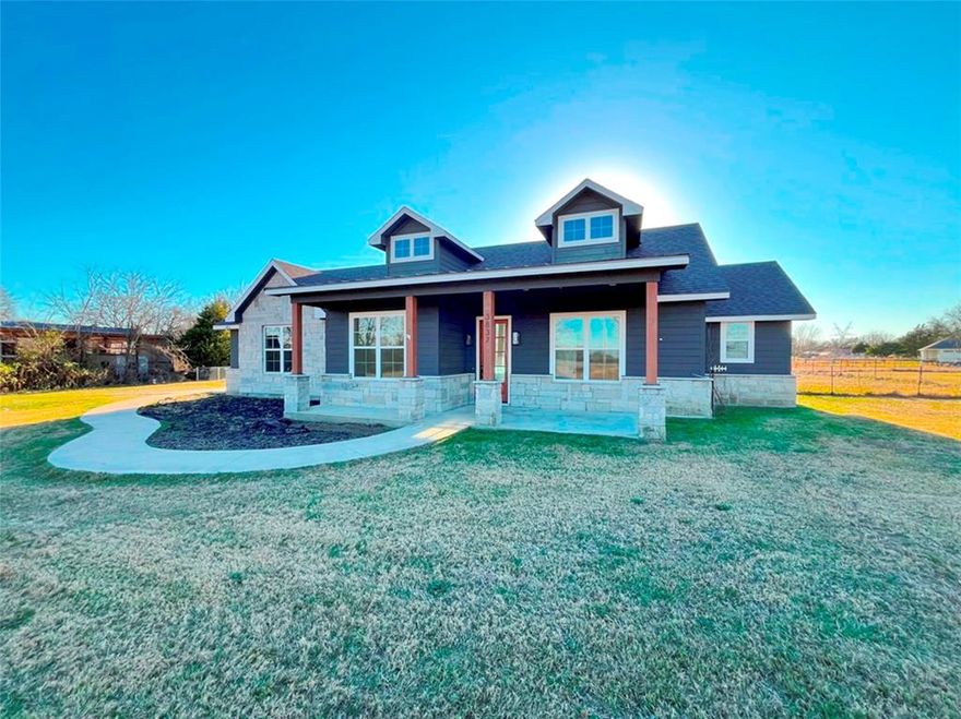 Take a look at this modern craftsman style residence on 2.45 acres in Wills Point, offering open-concept living and peaceful country surroundings including a scenic backyard. This inviting 3-bedroom, 2-bath home features a spacious living room with an eye-catching fireplace and a wall of windows showcasing the back yard. The kitchen includes white Quaker-style cabinetry, granite counters, stainless appliances, and a large island with seating, plus an adjacent dining room for gatherings. Wood-look ceramic tile extends through the main living areas. The generous primary suite offers an ensuite bath with a glass-enclosed tile shower, double vanity, and a walk-in closet with built-ins. Additional highlights include an oversized side-entry two-car garage, a welcoming covered front porch, and a substantial covered back patio opening to a fenced area that's perfect for entertaining or relaxing in a quiet scenic setting. Recent updates include fresh interior paint, new carpeting, new kitchen appliances, a new backyard fence, and more...making this home move-in ready!  This is a Fannie Mae Homepath Property...View it today. Note: Some images in this listing have been virtually staged.