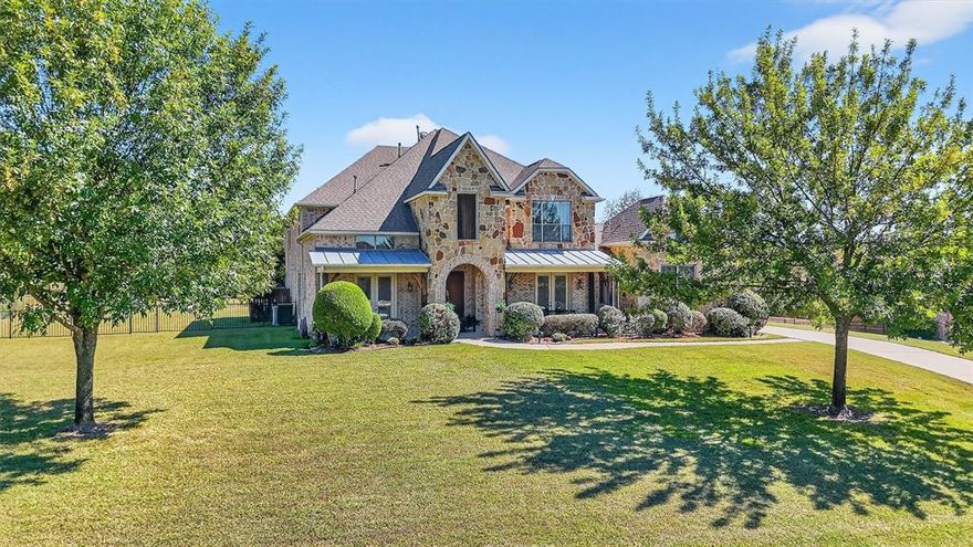 Beautiful 5-bedroom, 5 total bathroom home on 1 acre in the gated Stonegate neighborhood of Lucas. This well-maintained 4,577 sq ft home features a light-filled open layout with a 21’ tall entry, large living room with tiled gas log fireplace and views of the backyard oasis. The gourmet kitchen includes granite counters, a large island, gas cooktop, double ovens, solid oak cabinetry, walk-in pantry, and a charming breakfast nook. The spacious primary suite features a sitting area, and ensuite that includes a generous walk-in closet, jetted tub, separate shower, and dual vanities. A second downstairs ensuite bedroom with French doors leading to the front porch is ideal for guests or multigenerational living. Additional main-floor highlights include a formal dining room, private office with front porch access, half bath, wine grotto, a well-equipped laundry room, with a 2-car garage and adjoining 1 car garage. Upstairs features a large game room with wet bar, media room with coffered ceiling and sound system, and three generous bedrooms with ensuite or Jack-and-Jill baths. Ample attic storage is easily accessible. The resort-style backyard includes a sparkling saltwater pool, covered patio, scattered trees, and wrought-iron fencing. Located up the street from the White Rock Creek greenbelt and neighborhood park, this home offers peaceful country living just minutes from shopping and dining. No MUD or PID.