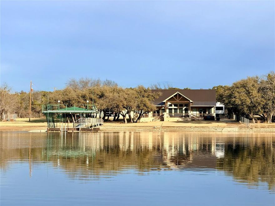 For buyers who really know PK, this is the location you waited for… quiet water, estate quality surroundings, and a private shoreline your family and guests will actually use. Nearly one acre with 255 ft lake front, mature grandfather oaks, irrigated lawn w lake pump, and a gentle walk to good depth under the dock. The cove provides safe, calm water for swimming and floating, while still offering lake views and quick access to marinas and dining. A long private drive and bordering woods create uncommon privacy. Custom built in 2019 as a full time residence, not a spec home. 3BR, 2.5BA with volume ceilings, tile floors throughout, expansive lake view windows, and a floorplan oriented to the lake from the moment you enter. Kitchen includes large island, quartz countertops, premium appliances, and extensive custom cabinetry. Oversized pantry doubles as a reinforced safe or storm room. Large utility room, exceptional storage, and thoughtful functional design throughout. Outdoor living is built for how PK is actually enjoyed... huge covered porch with outdoor kitchen and built-in grill, fire pit, porch swing, hot tub with remote access, and sunset exposure with prevailing summer breezes. Infrastructure matters here... Standing-seam metal roof, foam insulation, energy-recovery ventilation system, tankless propane water heater with recirculation, whole house Generac generator, and whole-house water treatment. Private boat ramp, covered boat slip with lift, stable pier, and upper party deck diving platform. Bonus 40ft x60 ft insulated metal building 2,400 sq ft with 14 x 14 door plus a glass lake facing garage door opening ideal for boat and RV storage, recreation, currently indoor pickleball, or workshop. A rare combination of protected water, usable land, private setting, quality construction, and long term livability. Plus income potential as a vacation rental… attributes difficult to find all together in one location on Possum Kingdom Lake.