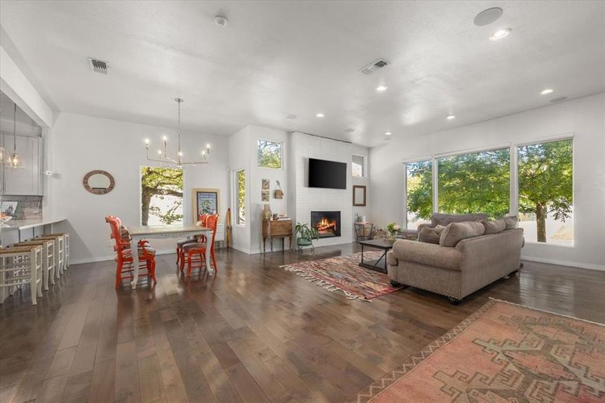 Tucked on a quiet, tree-lined street near Ridglea Country Club, this updated home combines timeless curb appeal with a modern, comfortable layout. The white brick exterior and mature landscaping lead to bright interiors with hardwood floors and abundant natural light. An open living area centers around a sleek fireplace and flows easily into the dining space and updated kitchen, which features soft gray cabinetry, stainless appliances, generous prep areas, and a large island plus additional peninsula for breakfast bar seating. The spacious primary suite offers a peaceful retreat with a walk-in closet and a spa-inspired bath featuring a soaking tub, glass shower, and dual vanity. Outside, layered patios shaded by mature trees create a private, inviting setting for entertaining or relaxing. A detached two-car garage completes the property.