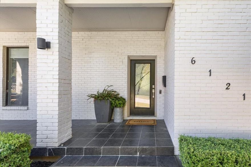 Tucked on a quiet, tree-lined street near Ridglea Country Club, this updated home combines timeless curb appeal with a modern, comfortable layout. The white brick exterior and mature landscaping lead to bright interiors with hardwood floors and abundant natural light. An open living area centers around a sleek fireplace and flows easily into the dining space and updated kitchen, which features soft gray cabinetry, stainless appliances, generous prep areas, and a large island plus additional peninsula for breakfast bar seating. The spacious primary suite offers a peaceful retreat with a walk-in closet and a spa-inspired bath featuring a soaking tub, glass shower, and dual vanity. Outside, layered patios shaded by mature trees create a private, inviting setting for entertaining or relaxing. A detached two-car garage completes the property.