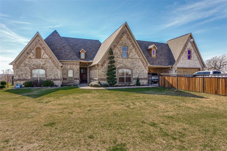 4.94 Acres in Paradise Texas with Pool! 4 beds, 2.5 baths, 2 living and Unfinished Bonus room(s) with HVAC. This sprawling cobblestone Tudor estate has a porte cochere with copper gutters, corbel accents and inlaid stone accents. The custom door welomes you into the grand living room with real wood floors, heavy textured archways and a vaulted beamed ceiling with raised hearth wood burning fireplace. The entertainer's kitchen has a pass through bar, glazed cabinets, walk-in pantry, built-in microwave, electric range w vent hood and tumble marble backsplash. The eat-in kitchen has a large breakfast room with wood-inlaid floors and bar stool seating looking onto the expansive patio. The primary ensuite boasts a tray ceiling, jacuzzi tub, large walk-in shower, dual-sink vanity, and walk-in closet. The split layout affords privacy with two additional beds down - each with direct access to the full bath with shower tub combo. This flex plan has a spacious second living down that could also serve as an in-law suite, playroom, media or grand office suite. Upstairs find an additional bed with half bath and an unfinished bonus suite with hvac. See drawing in transaction desk. Outside enjoy a 15x10 covered patio with vaulted pergola, an open patio, chlorine diving pool with grotto waterfall, bubbler beachfront sun ledge and firepit. Well with Leaf Home Water Solutions Softener. NEW Pool Auxillary Pump Motor, New Filter Pump Motor & Seal Kit and Hayward Omni Hub App Driven Control Panel. New Garage Door and Opener. New Water Softener. NEW Gutters. Newer water well couplings, wire and well pump.