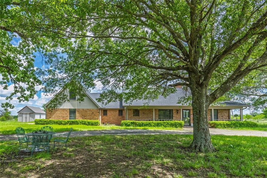 Welcome to your slice of country paradise! Nestled on 11.4 fully fenced acres, this charming 1980 brick ranch-style home offers the perfect blend of peaceful rural living with modern comforts. With approximately 1,763 sq ft of well-maintained space, this 3-bedroom, 2-bathroom residence features a thoughtful split-bedroom floor plan, perfect for both privacy and functionality. You'll immediately appreciate the spacious living area with a cozy gas log fireplace, ideal for relaxing evenings. The kitchen is well-appointed with a breakfast bar and ample cabinetry, flowing seamlessly into the dining area — great for everyday meals or entertaining guests. Enjoy serene views out of every window, with trees galore surrounding the home and a circle driveway welcoming you to the property. The master suite boasts dual sinks, a jetted tub, a separate shower, and an attached office or flex space — perfect for working from home or unwinding in your own private retreat. A large utility room adds to the convenience, and the attached 2-car garage provides secure parking and extra storage. Outside, the possibilities are endless. The property includes a barn, making it ideal for horses, cows, or other livestock. Whether you're looking to start a small homestead, garden, or simply enjoy the wide-open spaces, this property has the space and infrastructure to support your goals. This is true country living — quiet, open, and full of opportunity, yet still close enough to town for everyday essentials. Don't miss your chance to own this beautiful piece of Texas countryside. Come experience the charm and potential of this one-of-a-kind ranch property!