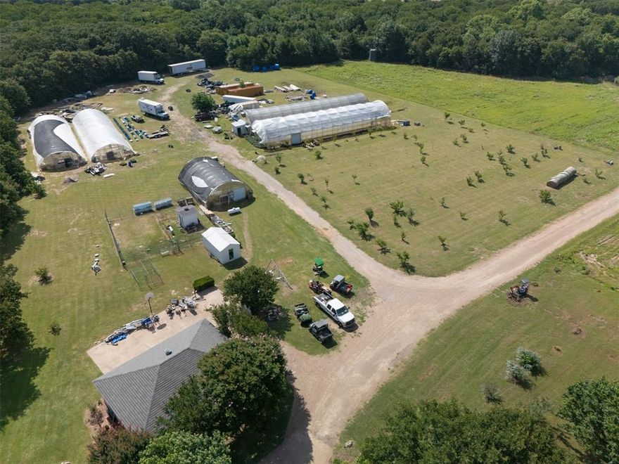 Turnkey North Texas Agribusiness Estate, Pool, Wine Cellar, Orchards & Commercial Facilities! Experience a rare opportunity to own a premier North Texas agricultural estate and luxury ranch property on 40.38 meticulously cross-fenced acres in the prestigious Alvarado area of Johnson County. This turnkey commercial agribusiness features 12,000 sq ft of hydroponic greenhouses with premium grow lights, climate control fans, and high-efficiency irrigation systems, plus over 15,000 sq ft of insulated metal buildings, a 2,000 sq ft walk-in cooler, and a 1,000 sq ft freezer. A dedicated showroom and manufacturing space with dock-height loading bays is ideal for product distribution and value-added production. The property includes sustainable solar power infrastructure for energy efficiency and thriving mature peach orchards supported by a fully operational irrigation and equipped pole barn. The main residence offers 4,400 sq ft within the total 19,000 sq ft of improvements, featuring 4 bedrooms, 3.5 baths, and a chef’s kitchen with dual islands and Miele appliances. Enjoy resort-style outdoor living with an in-ground pool and spa, outdoor kitchen, brick-oven patio, and pool house with a full bath. The estate also includes a detached 3-car garage, in-ground wine cellar, and a 1,200 sq ft guest house with full kitchen, laundry, and private living quarters, perfect for multi-generational living or staff accommodations. Built in 1992 with lasting craftsmanship, this secure, gated property offers co-op water, well-maintained septic, and easy access via asphalt and gravel roads. Perfect for luxury ranch buyers, commercial agricultural investors, or anyone seeking a high-value farm property near Fort Worth, this estate combines business potential with private, upscale living.