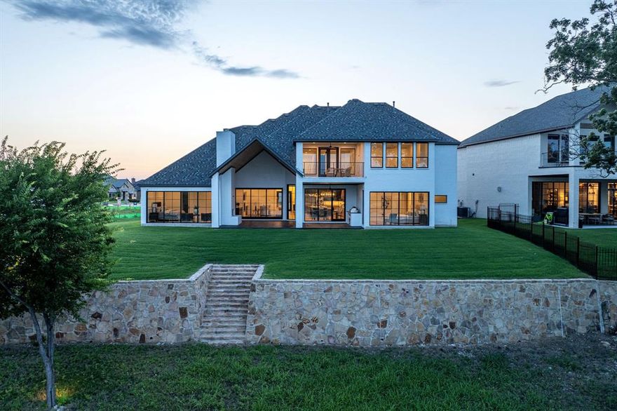 This exceptional Lake ray Hubbard residence is one of the rare homes perfectly positioned on the waterfront, offering picturesque views across the lake to the prestigious Heath Golf and Yacht Club clubhouse and community amenities. Nestled on a quiet street, this elegant home spans approximately 5,000 square feet across two well-appointed levels.

The main-floor houses two primary suites showcasing breathtaking lake views through a wall of expansive windows and features luxurious spa-style baths. Upstairs, you’ll find two additional bedrooms, each with its own en suite bath, a spacious media room, and a central living area that opens up to an outdoor patio ideal for relaxing or entertaining as you take in the tranquil lake views.

The gourmet kitchen is a chef’s dream, boasting an oversized island with bar seating, premium appliances, and ample prep space. Additional highlights include a private study located on the mezzanine level, a full laundry room, a dry bar, and a covered outdoor living space complete with fireplace and built-in grilling station. The home also offers a two-car garage plus a separate one-car garage, and a beautifully manicured putting green overlooking the water.

A rare opportunity to enjoy luxury lakefront living—this home truly has it all.