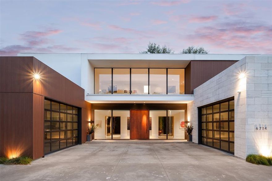 Private Architectural Modern behind gates in the heart of Preston Hollow, this striking contemporary estate blends bold architecture, refined detail, and seamless indoor-outdoor living. Designed and built by Chad Dorsey + MORE Design, the home offers a rare fusion of architectural pedigree, functionality, and integrated technology.

A gated circular motor court sets the tone, with dual two-car garages—one transformed into a climate-controlled collector’s showroom with lift, workshop, and storage. A dramatic two-story glass gallery with floating pivot entry creates a light-filled architectural spine, leading to museum-finish walls, Venetian plaster, slatted wood ceilings, and three fireplaces. Oversized 24

ft wide La Cantina sliding doors open for effortless indoors to outdoors entertaining and flow. A stunning four-sided 1200+ bottle glass wine gallery anchors the dining and kitchen, featuring Bulthaup cabinetry, Gaggenau appliances, and a walk-in pantry with temperature-controlled storage.

The first-floor primary suite offers a limestone spa-inspired bath, walk in shower + soaking tub, dual closets with tornado room, and private glass walled executive office overlooking the manicured rear yard. Outdoors, enjoy a resort-style pool with slide and chiller, putting green, turf lawn, mosquito misting system, and a covered pavilion with outdoor kitchen, drop-down screens, cooling misting, and heaters.

Upstairs includes four sophisticated ensuite bedrooms, a tv-media lounge with wet bar, fitness studio and powder bath with both living spaces connected to a tree house view terrace. Savant whole-home AV, electronic shades, WiFi 6, security, generator, elevator, walk out conditioned mechanical room, and whole-house systems complete this exceptional offering on a premier 100x160 lot.