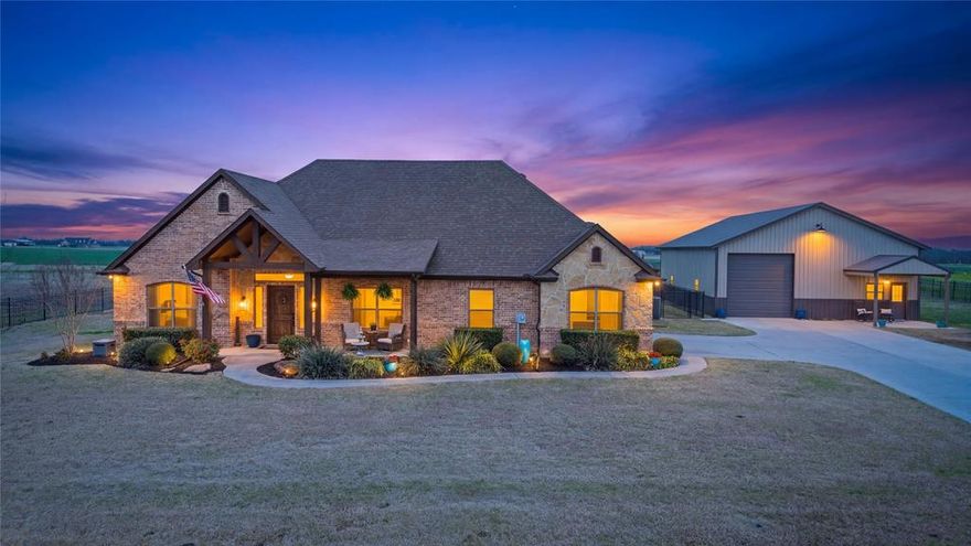 Welcome to a truly exceptional property in the highly sought-after Caddo Mills ISD, where thoughtful design, quality craftsmanship, and peaceful country living come together. Situated on 1.5 beautifully maintained acres and fully enclosed with wrought iron fencing, this home has been meticulously loved and maintained. In 2025, the home received several major updates including a new cooktop, wall oven, dishwasher, roof, exterior paint, full HVAC system, and new gutters, providing peace of mind for years to come.
Inside, you’ll find 4 spacious bedrooms, 2 bathrooms, and a dedicated office, ideal for working from home. The living room is nothing short of impressive with soaring 18-foot ceilings and a stunning floor-to-ceiling wood-burning fireplace that creates a warm, inviting atmosphere. Hand-scraped wood flooring adds timeless character, while granite countertops throughout bring both elegance and durability. The open-concept layout makes everyday living effortless and provides a wonderful space for entertaining family and friends. A two-car garage with additional storage offers practicality without sacrificing space. Step outside to enjoy the beautifully designed outdoor living area featuring a covered back porch with striking cedar beams and extended concrete, the perfect setting for relaxing evenings or weekend gatherings. For those needing additional workspace or storage, the impressive 50x36 metal shop with porch is fully equipped with electricity, ample outlets, WiFi, and two roll-up doors, making it ideal for hobbies, projects, business needs, or recreational storage. The grounds are just as impressive, featuring Bermuda grass, an irrigation system, and thoughtfully designed landscaping that enhances both beauty and usability.This property offers the rare opportunity to enjoy space, privacy, and modern comforts while remaining conveniently located to major roadways. Homes with this level of care rarely come available—making this one you won’t want to miss.