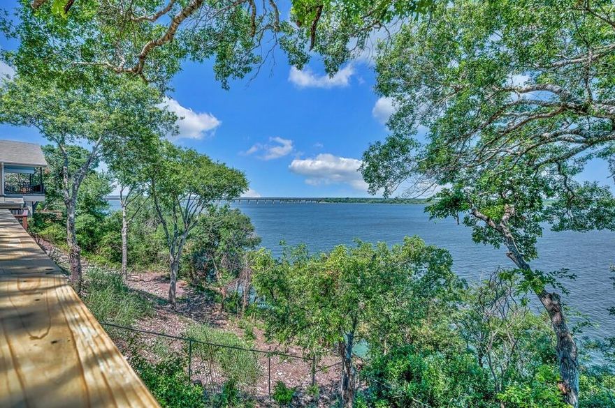W I D E   OP E N   V I E W....Rare Opportunity to own a Billion Dollar View of Lake Whitney!!! Along with a charming, updated 4 bedroom, 2 bath cottage, a newly installed deck over looking by far one of the most enviable VIEWS one can buy at any price. Entering the front door you are wowed by the magnificence of open water as far as can be seen to the left, right. Across not only the glistening blue water but a wild life area that can never be built on whose natural beauty and bird population changes with the seasons. Deck just removed and replaced means natural beauty and easy care increase enjoyment for many seasons ahead. Entire home refreshed with all new interior finishes to enhance the tranquil atmosphere. Granite in kitchen and both baths. Stainless appliances, elegant flooring of wood, tile and carpeting throughout. Main floor calming ambiance alleviates stress with 3 walls of windows framing this sensational view, wood burning fireplace and enticing kitchen. The bedroom and bathroom situated to sooth one into a restful sleep . The upper level is beautifully bathed with natural light and gorgeous views in bedrooms and the lovely bonus room.  Decompress while enjoying evenings watching sunsets and mornings you would never have imagined were possible as you breath in the fresh air.  Consider this very special feature: Use the property when you want, then let it pay for itself as an AIR B & B. The income potential of this property is extraordinary. An asset with this location, in an area so near the DFW Metroplex, even closer to Waco and Baylor University, offers endless opportunity to fill in time not used for personal use as a VRBO.  Can pay for itself, best of both worlds. Most of furnishings will convey,  set up move in ready.