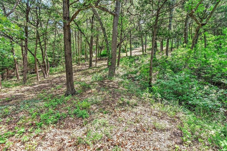 This is one of last, truly great lots available in Tanglewood Resort .  It is literally a 3 minute walk to Tanglewood's indoor and outdoor pools, and the Pickle Ball courts, or the two restaurants and two bars.  Or walk 4 minutes to your boathouse at Highport Marina, or enjoy another restaurant on the water.  Take your golf cart on the short ride to beautiful Tanglewood golf course also within the neighborhood .  This is a lot where you can build a leisure lifestyle on Beautiful Lake Texoma. The corner lot has 27,835 sq, ft. and sits on a gentle slope that goes down to a seasonal creek at the back or side of the property.  There is a mix of old oak trees as well as younger trees of several types.  Although the property address is on Lakewood St., it can be considered to front on Idlewild Dr as well, from which the resort is within view.  Come build your home where you can ride your golf cart or Side-by-side on the street or ride a four-wheeler through the surrounding woods.  The neighborhood is walking friendly, plays host to a Bicycle rally, is wonderfully kid-friendly, comfortable and safe.  Come walk this incredibly well-priced lot.
The only part of the lot within the flood plain is along the creekbed at the back of the property.