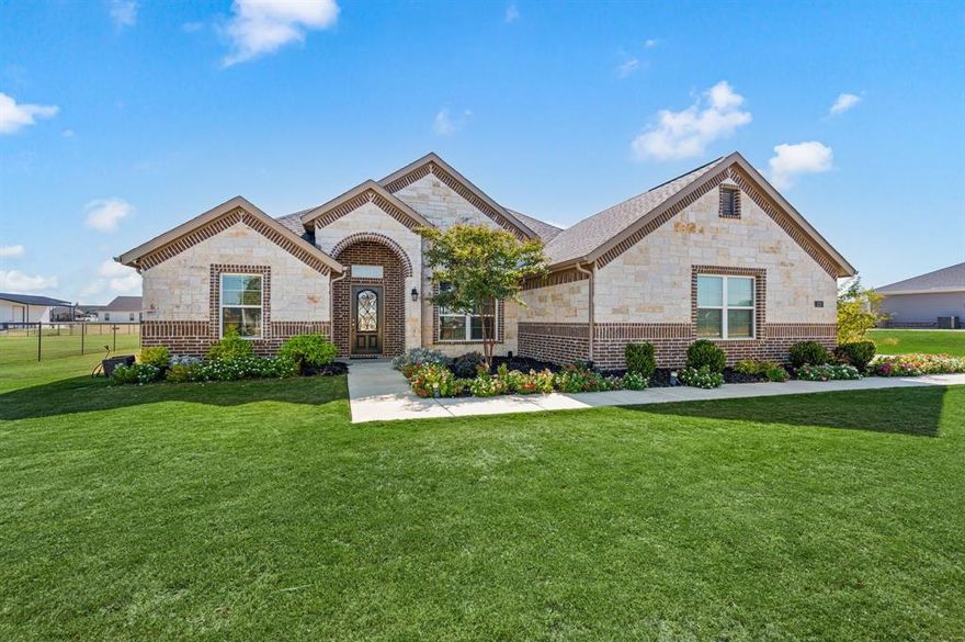 Welcome home to this beautiful 4-bedroom, 3-bath residence in Fairview Meadows—where modern comfort meets a peaceful country feel. Situated on a large lot in a community known for its wide-open spaces and impressive amenities—including a community pool, pickleball courts, dog park, fishing lake and walking trails—this home offers the best of both relaxation and recreation. Inside, a private office just off the entry provides the perfect workspace, while a nearby guest bedroom and full bath offer comfort and convenience for visitors. The heart of the home opens into a spacious living area centered around a stunning stone fireplace, seamlessly connecting to the chef’s kitchen featuring a large island ideal for entertaining, abundant cabinetry, and stainless steel appliances. Two additional guest bedrooms share a well-appointed bath, giving everyone space to unwind. The primary suite, tucked at the rear of the home for privacy, is a true retreat with a spa-like bath that includes dual vanities, a large walk-in shower, and a separate soaking tub. Step outside to a covered patio overlooking the expansive backyard, perfect for morning coffee, evening gatherings, or simply enjoying the peaceful surroundings. A three-car garage with epoxy floors adds functionality and a polished touch to this already impressive property. With its thoughtful layout, upscale finishes, and access to all that Fairview Meadows has to offer, this home combines comfort, style, and a touch of country charm—perfect for everyday living and entertaining alike.