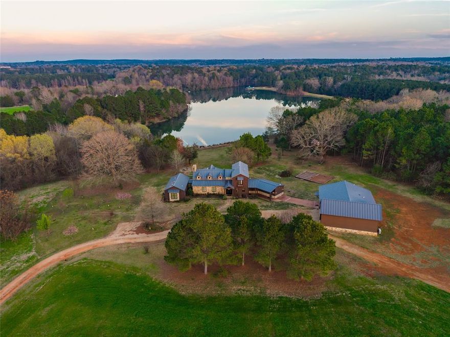 The Cross Pines Lake Retreat is an impressive residential and recreational property located just outside of Mineola, Texas.  The custom improvements feature a large, rustic-style home and a complementary shop with a panoramic view of one of the larger lakes, approximately 40 acres. This property is situated on a 5-acre deeded lot within the massive 2,100+ acre shared ownership property, Cross Pines Ranch. The ranch offers unmatched amenities and a rare opportunity to be a part of this relaxing and exclusive community.

LOCATION
The ranch is located approximately 10 miles northeast of Mineola in central Wood County. Multiple entryways along FM 49 provide easy access to the ranch and homesite. The improvements and lot are located on the western portion of the property.

IMPROVEMENTS
The custom home was constructed in 2009 and includes 4 bedrooms, 4.5 bathrooms, and is positioned to fully enjoy the lakeviews.  The 1st floor features two separate master bedrooms each with back patio access and large en-suite bathrooms.  A centrally located living space and connected master kitchen create a perfect setting for entertaining and enjoying the private lake views.  The large laundry room and half bathroom are located near the front entry with a bonus room or mancave connected to one of the downstairs master bedrooms.  The upstairs contains 2 bedrooms and 2 full bathrooms, perfect for children or guests.  Outside, the expansive back patio overlooks the lake and firepit area.  The adjacent shop resembles the home and includes parking, storage, an upstairs apartment, winch elevator, and capacity for a camper or RV.