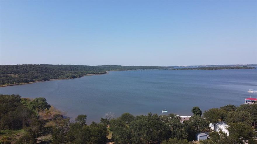 Welcome to 140 Meadow Pond Court, a fully furnished, beautifully updated 4-bedroom, 2-bath home offering 2,176 sq ft of comfortable living in the sought-after lakeside community of Runaway Bay. This property is perfectly positioned to capture peaceful views of Lake Bridgeport, making it an ideal retreat for full-time living or a relaxing weekend getaway. Step inside to find an inviting floor plan that blends modern updates with warm, livable charm. The home features durable vinyl plank wood flooring throughout the main living areas, while the bedrooms are finished with plush carpeting for added comfort. The spacious living room is perfect for gathering with family and friends, flowing easily into the open kitchen and dining area. With ample cabinetry and counter space, meal preparation and entertaining are effortless. The private primary suite offers a comfortable retreat, complete with a large closet and ensuite bath. Three additional bedrooms provide plenty of space for family, guests, or even a home office. Outdoor living is a highlight here. Relax on the covered back porch with a built-in hot tub while enjoying serene lake views, a perfect spot to unwind at the end of the day. The recently poured concrete driveway adds excellent curb appeal and convenience, and it has been thoughtfully designed with metal plates to allow for a future carport addition. A storage shed is also included, giving you extra space for tools, lake gear, or lawn equipment.
Located just minutes from QYB Resort, Runaway Bay Marina, and Downtown Bridgeport, this home offers easy access to boating, fishing, fine dining, and all the recreational opportunities the area is known for. With updates already complete and room for your personal touches, this property is move-in ready and waiting for its next owner. Don’t miss your chance to own this well-maintained home with lake views, modern upgrades, and endless potential.