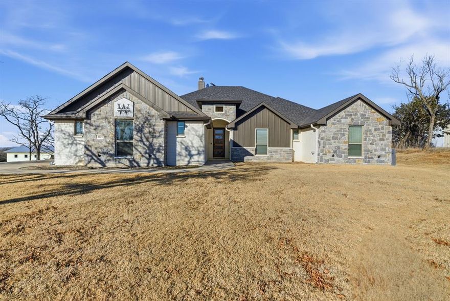 If you’ve been dreaming about a place where life slows down just enough to actually enjoy it, this is it. Set on a full 1 acre in Bulldog Crossing, this newer 4-bedroom home gives you the space to breathe, grow, and create the lifestyle you’ve been craving. Mornings here start with quiet skies, fresh air, and room to move whether that’s kids playing in the yard, coffee on the back porch, or finally having space between you and the neighbors. Inside, the home feels open, bright, and welcoming from the moment you walk in. The vaulted ceilings, open floor plan, and stone fireplace make the living area feel both spacious and cozy at the same time perfect for movie nights, holidays, or just everyday living that feels a little more special. The kitchen is truly the heart of the home, designed for real life and real gatherings. You’ll love the large island, granite countertops, and brand-new appliances, including a sleek induction oven that cooks fast and efficiently. Whether you're hosting friends or making a simple weeknight dinner, this space was made to be used and enjoyed. The private primary suite gives you a place to unwind at the end of the day, with a spacious bedroom and a spa-like bath featuring dual sinks, a soaking tub, and a separate shower. The additional bedrooms offer flexibility for guests, kids, or the home office everyone needs now. And then there’s the land the part you can’t remodel or recreate later. There’s room here for a future shop, a pool, a garden, play equipment, or simply wide-open space to enjoy Texas sunsets. No HOA means more freedom to actually use your property the way you want to. Even the garage is upgraded with built-ins, giving you extra storage and workspace for tools, hobbies, or weekend projects. Located in Millsap ISD with an easy drive to Weatherford, you get the peace of country living without feeling far from town.