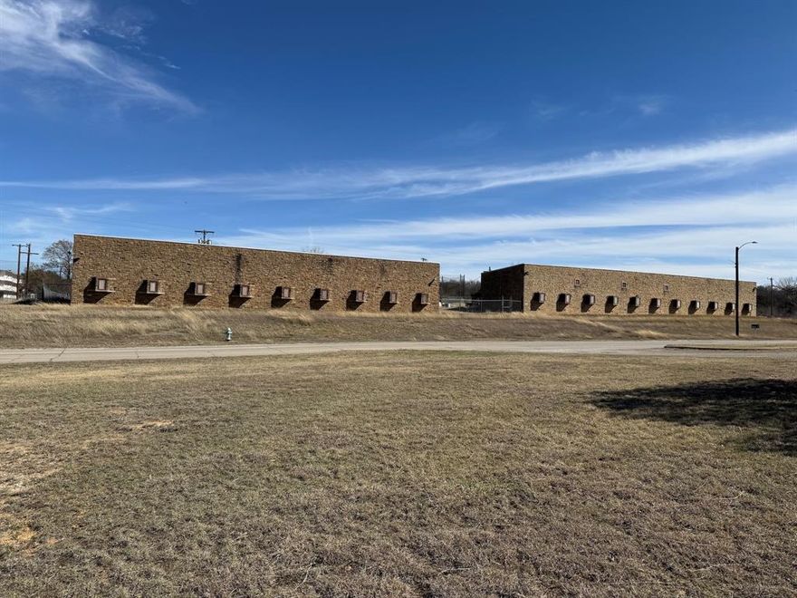 two warehouse buildings on a fenced lot