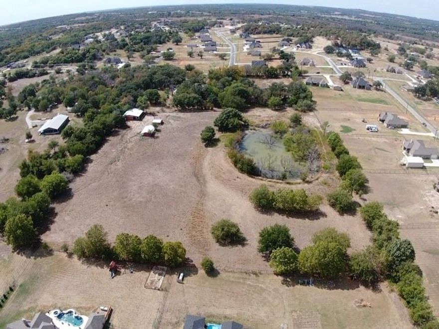 A large pond sits on this private piece of land with no restrictions. You could build your dream home on the hill that overlooks the pond, or build more than one residence, with plenty of room between them. When it rains, the pond receives a refill from the water that flows from Sandlin Lane into the pond. There is a lean-to on the property and a small shop. Come see this pretty, private land that's a perfect place to build a home.
Property has been subdivided into the currently listed 5.718 acres. There is an access easement from Sandlin that goes back through second gate on this property.