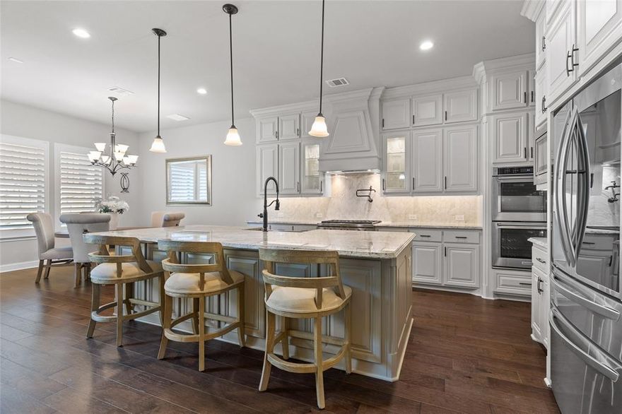 Just listed in the exclusive and gated Paradiso Valle of Stonebridge Ranch! Looking for exceptional finishes in a better than new 2021 built home with all the extras? From the moment you step through the handsome iron door into the two-story foyer, you’re greeted by a gorgeous wood and iron staircase and a 20ft vaulted, open-concept great room with a massive floor-to-ceiling stone fireplace. An equal showstopper is the superb island kitchen, featuring a gorgeous chevron-style marble backsplash, pot filler, glass-front & double-stacked cabinets to the ceiling, high-level granite, pendant lighting, double convection ovens, a Wolf 6-burner cooktop, farmhouse sink and a walk in pantry room. Hickory wood floors in an espresso finish grace the main areas downstairs. Retreat to the first floor primary suite, a true sanctuary boasting tray ceilings, a spa-like bath with a free standing soaking tub, and an oversized walk-in closet. Also on the main level: a guest or MIL suite with step in shower, a study or office with glass doors, a flex or entertainment room & under stair wine nook. Upstairs, both a game room loft and a media with 5.1 surround-projector & screen to convey, anchor the third and fourth bedrooms, providing a perfect secondary living zone. ALL bedrooms have ensuite baths. ALL 5 wall mounted TV's convey. Entertain with ease on the patio with a built-in, never-used KitchenAid gas grill, dual-burner cooktop, & sink. In wall pest defense system. 138K in total options and upgrades. You will enjoy the benefits of a secure, boutique-style, smaller community, yet all the benefits of the Stonebridge Ranch amenities: Aquatic center, tennis, golf, pickleball, basketball, lakes, and parks and trails. Zoned for top-rated McKinney schools, 5–10 minutes to HEB, Whole Foods Market, shops, dining and Adriatica Village. 12 minutes to downtown McKinney, 5 minutes to Baylor Scott and White Hospital, 15 minutes to the DNTollway, 19 minutes to the PGA District.