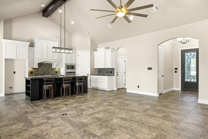 Motivated sellers! Captivating 4 bedroom PLUS an office on a .54 acre fenced lot in gated community of De Cordova Ranch. Soaring vaulted ceilings, natural light from the wall of windows and a centrally located stone hearth LP fireplace make this living room the heart of the home and a perfect place to entertain. The kitchen features gas cooking, undermount lighting, spacious island with bookcase end, generous pantry, coffee bar area with tons of storage and stainless steel appliances. Owners suite is a spacious retreat with tray ceiling with up lighting, ceiling fan, views to the backyard and a spectacular ensuite bath with double vanities-one with seating area, separate walk in shower, jetted tub and ENORMOUS closet with built in mirror and shelving. Secondary bedroom at front of home in office hallway with bath and 2 other split bedrooms on other side of the home with full bath. Separate laundry room with hanging area or room for 2nd fridge, and cabinets. Footlocker area makes keeping things tidy a breeze. Outside features include a covered patio, pipe fenced backyard and irrigated lawn with plenty of room for a pool!. 2 water heaters new as of Nov 2024 and AC condenser is new this year. Epoxy floor in garage. Community Center featuring open landscaped park, equipped playground area, picnic tables and outdoor grills, covered pavilion with bathrooms and kitchen.