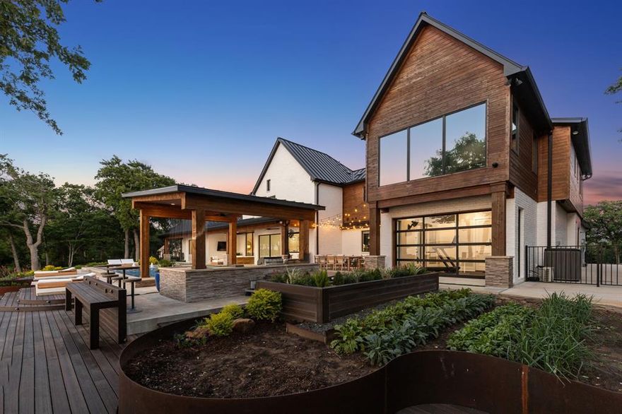 Perched on one of the highest elevated lots on Lake Lewisville, this stunning custom estate embodies the essence of refined lakefront living. Designed with timeless architecture, crisp white-painted brick, rich wood accents, and sleek black metal roofing, the residence offers breathtaking panoramic views and seamless indoor-outdoor living. Ideally located just 20 minutes from Frisco, TX, this lakeside retreat perfectly balances luxury and accessibility. Step inside to an open-concept layout flooded with natural light, featuring a designer kitchen with dual islands, premium appliances, and expansive glass doors that invite you to a resort-style backyard. Outside, indulge in a sparkling pool with cascading water features, a sunken fire pit lounge, a covered patio with a fully equipped outdoor kitchen, and multiple lounge areas overlooking the lake. A lush garden enhances the outdoor experience, offering a serene space for relaxation or cultivating homegrown produce. Modern technology meets luxury with a state-of-the-art Control4 system, granting seamless control of lighting, security, climate, and multi-room audio zones—all at your fingertips. Effortlessly set the perfect ambiance with synchronized audio both indoors and out, elevating every gathering and quiet moment alike. A private, lakeview gym with a roll-up glass door, spacious bedrooms, and a serene owner’s suite complete this retreat—all meticulously designed for everyday luxury and grand entertaining. This is a rare opportunity to own one of Lake Lewisville’s most exclusive waterfront properties, showcasing unmatched elevation, privacy, and architectural excellence.