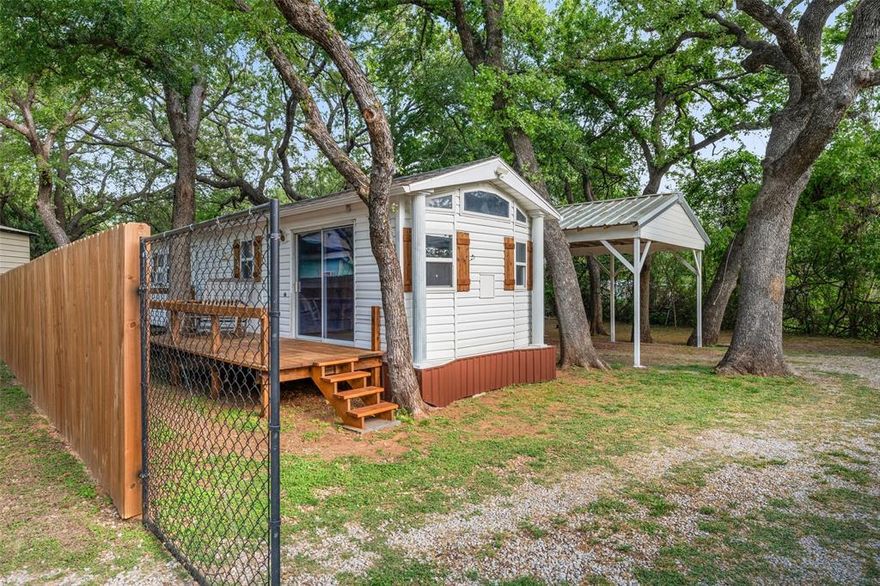 Located inside Indian Harbor gated community, this approximately 420sqft with an additional building that is setup as another bedroom at 184 sqft, this  tiny home offers a unique opportunity for downsizing, investment, or a weekend lake retreat. Nestled on a beautifully treed lot with mature shade trees, this property delivers both privacy and potential.

The home is move in ready, making it ideal for buyers looking to customize or add value. A separate insulated outbuilding with electricity and washer and dryer hookups provides incredible flexibility—perfect for conversion into a guest room, office, or additional living space.

Enjoy the convenience of covered parking, ideal for your vehicle, boat, or camper.

Indian Harbor residents enjoy access to amenities including a marina, boat dock, clubhouse, swimming pools, and gated security—bringing lake life and community living together in one place.