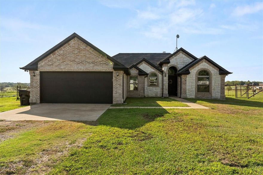 Discover country living with city convenience in this charming 3-bedroom, 2-bathroom home on 1 acre. Located just 45 minutes from Dallas and 30 minutes from Rockwall, this property offers space to breathe while staying connected. Inside, you’ll find an inviting open floor plan highlighted by a stunning floor to ceiling stone wood-burning fireplace, fresh interior paint, and a variety of custom finishes that add warmth and style. The large windows bring in natural light and showcase the beautiful views of the surrounding landscape. This property has NO RESTRICTIONS, so bring your plans for a shop, pool, or any additional buildings! With plenty of room for outdoor living, gardening, or simply enjoying peaceful sunsets, this home is the perfect blend of comfort and character.