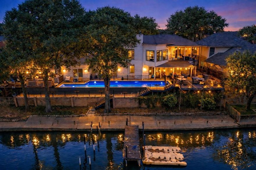 Tucked away in the prestigious waterfront enclave of Shorewood Estates, this extraordinary Lake Arlington residence delivers a rare combination of architectural character, luxury finishes, and true lake lifestyle living. Positioned along a peaceful canal with direct lake access, this custom designed home offers over 3,000 square feet of refined living space paired with exceptional outdoor entertaining. Step inside to soaring ceilings, and expansive living spaces filled with natural light. The main living room features a stunning fireplace and oversized windows that frame the tranquil waterfront setting, creating a warm and inviting atmosphere for both everyday living and elegant entertaining. The kitchen is designed for both functionality and style, offering granite countertops, an island workspace, abundant cabinetry, and a butler's pantry that provides additional prep and storage space. Decorative lighting and thoughtful design elements add to the home's distinctive character. The private primary retreat offers a luxurious escape complete with its own fireplace, sitting area, and spa inspired ensuite bath featuring dual vanities, separate shower, and custom walk in closet systems. Outdoor living is where this property truly shines. An elevated deck overlooks the canal and opens to a unique private lap pool that stretches alongside the home. Just steps away, your private dock provides convenient access to Lake Arlington for boating, fishing, and sunset cruises. Additional highlights include a pool house, greenhouse, circular drive, smart home features, and multiple fireplaces throughout the home. The property also offers ample space for boat and RV parking. Located within Arlington ISD and just minutes from shopping, dining, and major commuting routes, this home delivers the perfect blend of privacy, luxury, and waterfront lifestyle. This is a rare opportunity to own one of Arlington's most distinctive lakefront homes.