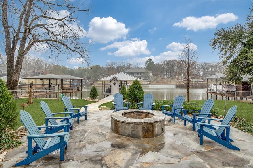 Luxury, turn-key Cedar Creek Lake retreat in a large, beautiful ski cove with 120’ of shoreline! Completely reimagined approximately 4 years ago, this 4-bed, 3-bath lake house is designed for effortless weekends and unforgettable gatherings. An expansive back deck with cascading stairs leads to a beautifully landscaped yard with flagstone pathways, a flagstone firepit, and a true destination dock. Enjoy an oversized dock with storage room, lounge seating and TV overlooking the cove, plus all-electric lifts including a tritoon lift and two jet-ski cradles—ready for lake days from sunrise to sunset.

Inside, the open kitchen shines with granite countertops, stainless appliances, island seating, and a breakfast area. Great for entertaining and hosting during holidays! Flexible sleeping plan features two private suites, one on the main level and one upstairs with a private balcony, plus additional guest rooms for hosting a crowd. The formal dining space is currently styled as a fun game zone with ping pong and darts. Offered fully furnished and turn-key with furniture, beds, linens, pots, pans and a fully stocked kitchen setup; Outdoor table, chairs, rockers, Blackstone Grill, Webber Grill, and adirondack chairs. Washer, dryer, and stainless steel refrigerator too!  All convey with acceptable offer.

Optional lake-toys package available: 2016 Xcursion tritoon with 200HP Yamaha (incl. trailer) and 2019 Yamaha VX Limited HO jet ski (incl. trailer) may convey via separate bill of sale.

Additional lot with storage building and towering trees across the street from home is available for purchase as well.  The lot is currently being used for overflow parking, trailer storage, and additional wood for fire pit.

A rare combination of beautiful ski-cove, wide shoreline, and move-in ready lake living—just bring your weekend bag.